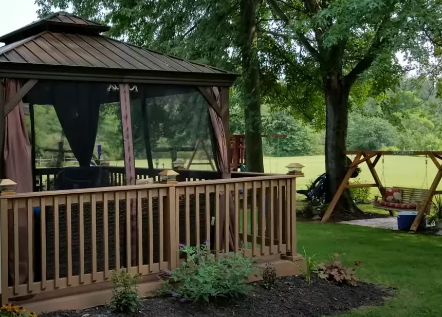 A gazebo on a wooden deck, demonstrating the possibility of placing a gazebo on a deck. The image showcases a beautifully designed gazebo surrounded by lush greenery, providing an inviting outdoor space. The gazebo's presence on the deck exemplifies the question, 'Can You Put Gazebo on Deck?'"